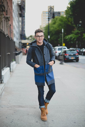 С чем носить темно-серое длинное пальто в 20 лет: Лук из темно-серого длинного пальто и темно-синих зауженных джинсов выглядит круто и по моде. Создать интересный контраст с остальными элементами этого образа помогут светло-коричневые замшевые рабочие ботинки.