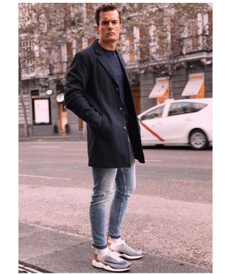 Как носить голубые рваные зауженные джинсы с белыми кроссовками в 30 лет мужчине в холод: Черное длинное пальто идеально сочетается с голубыми рваными зауженными джинсами. Белые кроссовки гарантируют комфорт в движении.