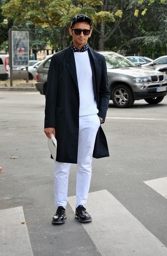 Модный лук: черное длинное пальто, белый свитер с круглым вырезом, черно-белая рубашка с длинным рукавом в горошек, белые брюки чинос