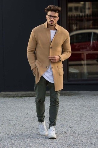 С чем носить темно-зеленые джинсы мужчине в холод: Светло-коричневое длинное пальто будет смотреться выигрышно с темно-зелеными джинсами. Ты можешь легко адаптировать такой образ к повседневным реалиям, надев белыми кожаными низкими кедами.