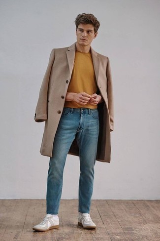 Модный лук: светло-коричневое длинное пальто, табачная футболка с круглым вырезом, синие джинсы, белые низкие кеды из плотной ткани