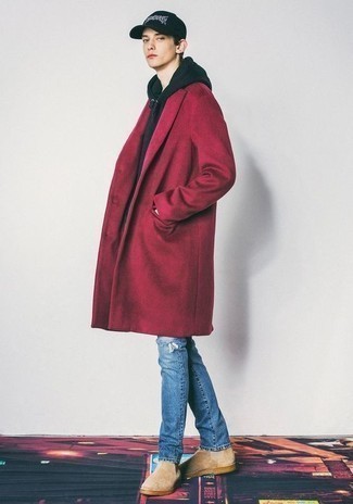 С чем носить темно-красное длинное пальто подросткам: Темно-красное длинное пальто в паре с синими рваными джинсами — классная идея для создания мужского образа в стиле business casual. Любители экспериментов могут завершить лук бежевыми замшевыми ботинками челси, тем самым добавив в него немного строгости.