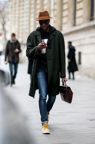 Как носить темно-зеленое длинное пальто с темно-синими джинсами в прохладную погоду в стиле кэжуал: Сочетание темно-зеленого длинного пальто и темно-синих джинсов — нескучный образ для офиса. Ты можешь легко адаптировать такой лук к повседневным нуждам, дополнив его бежевыми высокими кедами из плотной ткани.