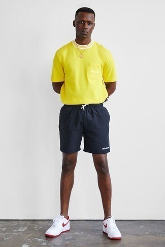 Какие кроссовки носить с желтой футболкой с круглым вырезом мужчине в жару: Тандем желтой футболки с круглым вырезом и темно-синих спортивных шорт - самый простой из возможных ансамблей для активного досуга. Вместе с этим образом чудесно смотрятся кроссовки.