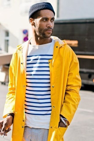 Модный лук: желтый дождевик, бело-темно-синяя футболка с длинным рукавом в горизонтальную полоску, серые брюки чинос, темно-синяя шапка