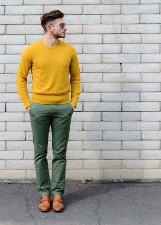С чем носить зеленые брюки чинос в 20 лет: Сочетание желтого свитера с круглым вырезом и зеленых брюк чинос позволит подчеркнуть твой личный стиль. Почему бы не привнести в этот ансамбль на каждый день толику нарядности с помощью светло-коричневых кожаных монок с двумя ремешками?