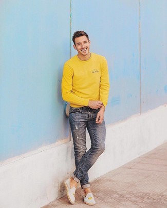 С чем носить синие рваные джинсы в 30 лет мужчине в спортивном стиле: Сочетание желтого свитшота и синих рваных джинсов - очень практично, и поэтому идеально для создания беззаботного повседневного  образа. Хочешь добавить в этот лук нотку классики? Тогда в качестве дополнения к этому образу, выбери белые эспадрильи из плотной ткани с вышивкой.