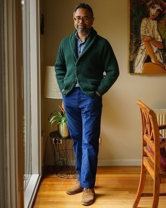 Как носить бежевые замшевые туфли дерби с синими джинсами за 50 лет в теплую погоду в стиле смарт-кэжуал: Темно-зеленый кардиган с отложным воротником и синие джинсы — обязательные вещи в гардеробе джентльменов с чувством стиля. Если ты предпочитаешь смелые настроения в своих ансамблях, закончи этот бежевыми замшевыми туфлями дерби.