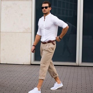 Модный лук: белая классическая рубашка, бежевые брюки чинос, белые кожаные низкие кеды, темно-коричневый кожаный плетеный ремень