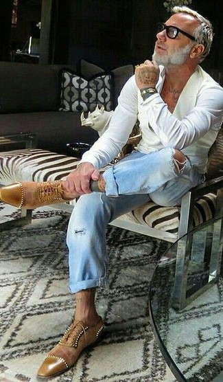Как носить голубые джинсы с белой рубашкой мужчине в стиле смарт-кэжуал: Тандем белой рубашки и голубых джинсов позволит составить необыденный мужской лук в расслабленном стиле. Если ты любишь смелые решения в своих образах, закончи этот светло-коричневыми замшевыми оксфордами.