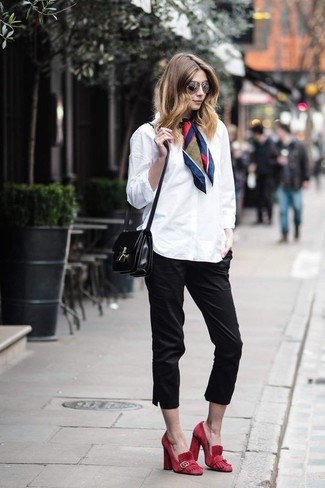 С чем носить черные капри в 20 лет в деловом стиле: Дуэт белой классической рубашки и черных капри выглядит очень классно и модно. Пара красных замшевых туфель удачно интегрируется в этот наряд.