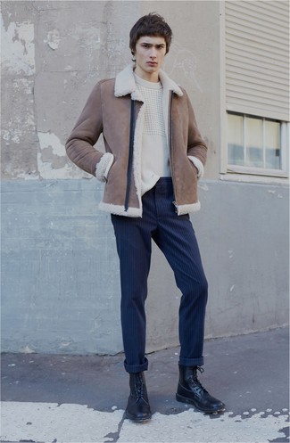 Модный лук: коричневая короткая дубленка, белый вязаный свитер, темно-синие брюки чинос в вертикальную полоску, черные кожаные повседневные ботинки