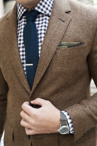 Модный лук: коричневый пиджак с узором "в ёлочку", бело-темно-синяя рубашка с длинным рукавом в мелкую клетку, темно-синий вязаный галстук, оливковый нагрудный платок в шотландскую клетку