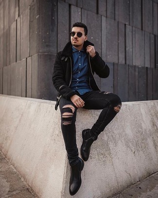 Как носить темно-синюю рубашку с длинным рукавом из шамбре с черными кожаными ботинками челси мужчине в прохладную погоду: Если ты ценишь комфорт и практичность, темно-синяя рубашка с длинным рукавом из шамбре и черные рваные зауженные джинсы — хороший выбор для стильного мужского ансамбля на каждый день. Любишь необычные луки? Закончи образ черными кожаными ботинками челси.