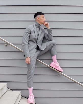 С чем носить ярко-розовые носки в 20 лет мужчине в теплую погоду в стиле смарт-кэжуал: Практичное сочетание серого костюма и ярко-розовых носков несомненно будет привлекать взгляды красивых девушек. Почему бы не привнести в этот лук немного фривольности с помощью розовых кроссовок?