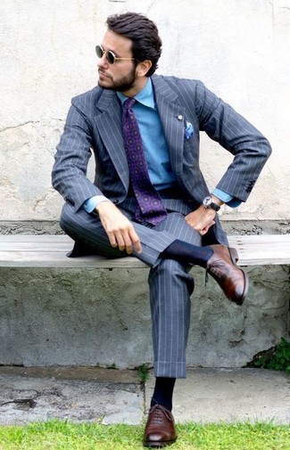 С чем носить темно-синюю джинсовую рубашку мужчине в теплую погоду в деловом стиле: Темно-синяя джинсовая рубашка и серый костюм в вертикальную полоску — отличный вариант для повседневного офисного образа. Не прочь сделать образ немного строже? Тогда в качестве обуви к этому луку, выбирай коричневые кожаные оксфорды.