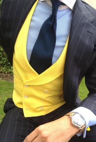 С чем носить золотой жилет в теплую погоду: Золотой жилет в сочетании с черным костюмом в вертикальную полоску позволит составить эффектный мужской образ.