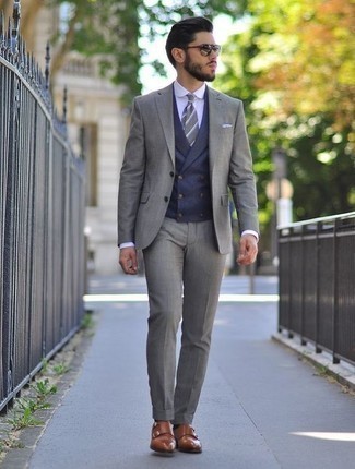 С чем носить темно-серый галстук в горизонтальную полоску мужчине осень в деловом стиле: Любой мужчина будет выглядеть отменно в сером костюме и темно-сером галстуке в горизонтальную полоску. Ты можешь легко приспособить такой образ к повседневным условиям городской жизни, надев коричневыми кожаными монками с двумя ремешками. Как нам кажется, это хороший вариант в ласковый осенний денек.