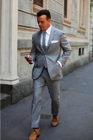 С чем носить темно-серый шерстяной галстук мужчине: Сочетание серого шерстяного костюма и темно-серого шерстяного галстука — великолепный пример строгого мужского стиля. Коричневые замшевые ботинки дезерты позволят сделать образ менее официальным.