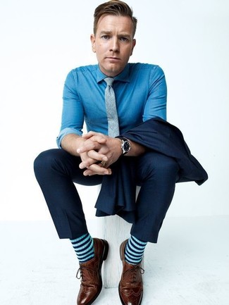 Как Ewan McGregor носит Темно-синий костюм, Синяя классическая рубашка из шамбре, Коричневые кожаные броги, Серый галстук