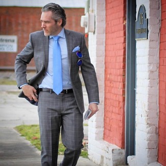 С чем носить голубой галстук мужчине: Сочетание серого костюма в шотландскую клетку и голубого галстука уместно для создания делового образа.