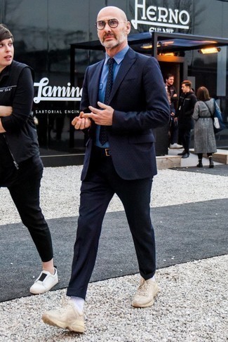 С чем носить синий галстук в горошек мужчине в стиле смарт-кэжуал: Темно-синий шерстяной костюм в горошек в сочетании с синим галстуком в горошек — прекрасный пример строгого мужского стиля. Если сочетание несочетаемого импонирует тебе не меньше, чем проверенная классика, закончи свой наряд бежевыми кроссовками.