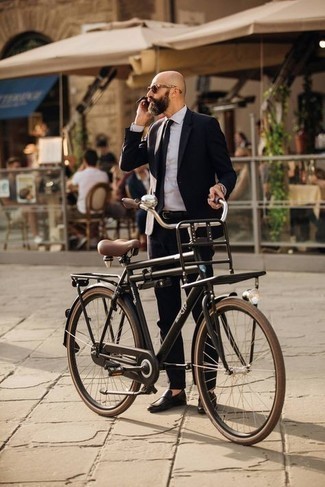 Модный мужской лук: черный костюм, белая классическая рубашка, темно-коричневые кожаные лоферы, черный галстук