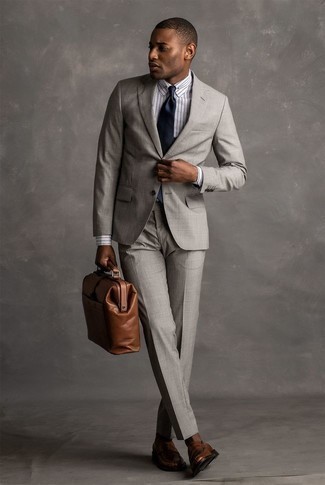 С чем носить темно-синий шелковый галстук мужчине в деловом стиле: Несмотря на то, что этот образ достаточно классический, сочетание серого костюма и темно-синего шелкового галстука является постоянным выбором современных джентльменов, неминуемо покоряя при этом дамские сердца. Такой образ несложно адаптировать к повседневным нуждам, если дополнить его коричневыми кожаными лоферами.
