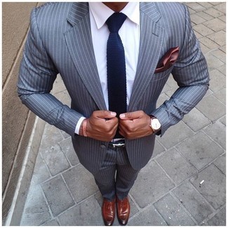 С чем носить темно-синий вязаный галстук мужчине в теплую погоду: Сочетание серого костюма в вертикальную полоску и темно-синего вязаного галстука подходит для создания делового ансамбля. Такой образ легко адаптировать к повседневным нуждам, если дополнить его коричневыми кожаными лоферами с кисточками.