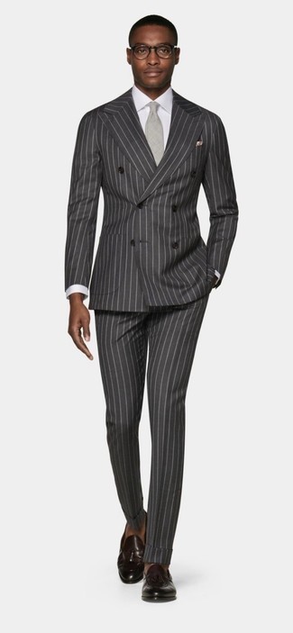 С чем носить темно-серый галстук мужчине: Сочетание темно-серого костюма в вертикальную полоску и темно-серого галстука подходит для воплощения делового лука. В тандеме с темно-коричневыми кожаными лоферами с кисточками весь лук выглядит очень динамично.
