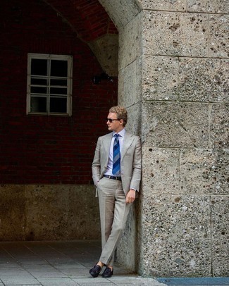 С чем носить синий галстук в горизонтальную полоску в 30 лет мужчине в теплую погоду: Комбо из серого костюма и синего галстука в горизонтальную полоску позволит создать стильный и в то же время изысканный лук. Ты можешь легко приспособить такой ансамбль к повседневным реалиям, завершив его темно-коричневыми кожаными плетеными лоферами с кисточками.