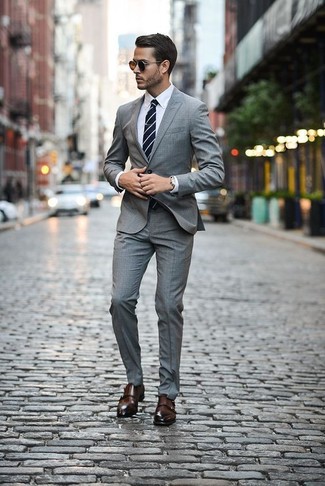 С чем носить темно-синий галстук в горизонтальную полоску в 30 лет мужчине в теплую погоду: Серый костюм в шотландскую клетку в паре с темно-синим галстуком в горизонтальную полоску — превосходный пример строгого делового стиля. Создать красивый контраст с остальными предметами из этого ансамбля помогут темно-коричневые кожаные монки с двумя ремешками.