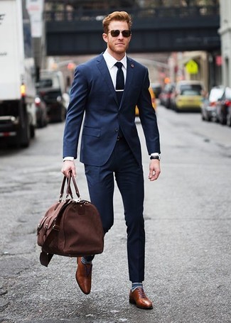 С чем носить темно-синие носки в горизонтальную полоску мужчине в теплую погоду: Если ты любишь выглядеть с иголочки, и при этом чувствовать себя комфортно и нескованно, тебе стоит примерить это сочетание темно-синего костюма и темно-синих носков в горизонтальную полоску. Этот лук легко получает новое прочтение в сочетании с коричневыми кожаными оксфордами.