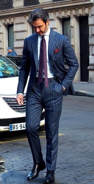С чем носить фиолетовый галстук за 40 лет мужчине лето в деловом стиле: Несмотря на то, что это довольно-таки сдержанный лук, дуэт темно-синего костюма в вертикальную полоску и фиолетового галстука является неизменным выбором стильных мужчин, непременно покоряя при этом сердца прекрасных дам. Ты можешь легко приспособить такой лук к повседневным условиям городской жизни, закончив его черными кожаными оксфордами. Такое сочетание одежды несомненно поможет перенести изнурительный летний зной.