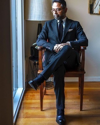 С чем носить темно-сине-белый вязаный галстук мужчине в деловом стиле: Комбо из темно-синего шерстяного костюма и темно-сине-белого вязаного галстука поможет создать стильный и утонченный лук. В сочетании с темно-синими замшевыми повседневными ботинками весь лук выглядит очень динамично.