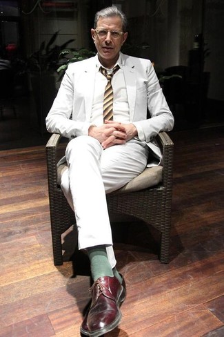 С чем носить зелено-желтый галстук за 50 лет мужчине: Белый костюм и зелено-желтый галстук позволят создать изысканный мужской лук. Такой ансамбль легко приспособить к повседневным условиям городской жизни, если надеть в тандеме с ним темно-красные кожаные туфли дерби.