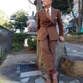 С чем носить темно-коричневый костюм за 60 лет: Комбо из темно-коричневого костюма и белой классической рубашки позволит создать стильный и мужественный лук. Если ты любишь экспериментировать, на ноги можешь надеть коричневые кожаные туфли дерби.