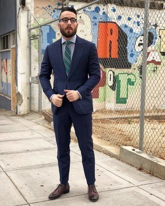 С чем носить темно-зеленый галстук в горизонтальную полоску мужчине: Несмотря на то, что этот образ выглядит довольно-таки сдержанно, тандем темно-синего костюма в вертикальную полоску и темно-зеленого галстука в горизонтальную полоску всегда будет по вкусу стильным мужчинам, пленяя при этом сердца прекрасных дам. Такой образ легко адаптировать к повседневным реалиям, если надеть в тандеме с ним темно-красные кожаные туфли дерби.