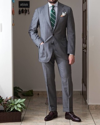 С чем носить темно-зеленый галстук в горизонтальную полоску мужчине лето: Комбо из серого костюма и темно-зеленого галстука в горизонтальную полоску — превосходный пример строгого делового стиля. Завершив лук темно-красными кожаными туфлями дерби, можно привнести в него немного беззаботства. Весьма подходящая идея для удобного летнего образа.