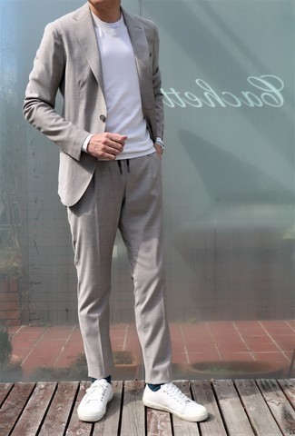 Модный лук: серый костюм, белый свитер с v-образным вырезом, белая футболка с круглым вырезом, белые низкие кеды из плотной ткани
