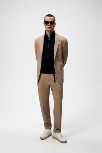 Модный лук: светло-коричневый костюм, черный свитер с воротником на молнии, белые кожаные низкие кеды, темно-коричневые солнцезащитные очки