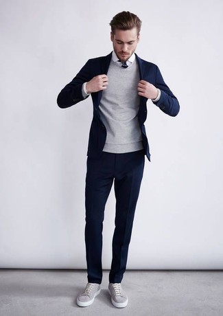 Модный лук: темно-синий костюм, серый свитер с круглым вырезом, белая классическая рубашка, серые низкие кеды
