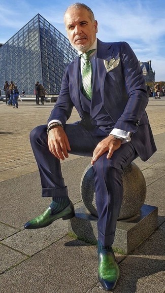 С чем носить зеленый галстук с принтом за 50 лет мужчине: Темно-синий костюм-тройка в вертикальную полоску и зеленый галстук с принтом — превосходный пример элегантного стиля в одежде. Любишь смелые решения? Тогда заверши свой лук зелеными кожаными лоферами.