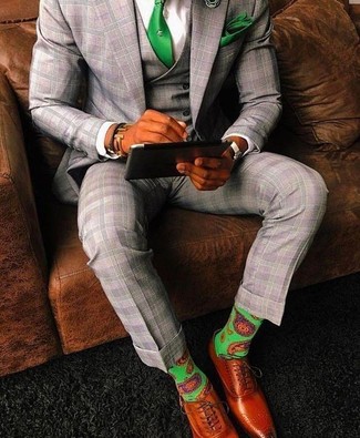 С чем носить зеленые носки с принтом мужчине: Серый костюм-тройка в шотландскую клетку и зеленые носки с принтом прочно закрепились в гардеробе современных парней, позволяя создавать яркие и комфортные луки. Хотел бы добавить сюда толику строгости? Тогда в качестве обуви к этому образу, стоит выбрать табачные кожаные оксфорды.