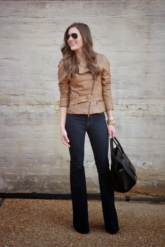 Модный лук: светло-коричневая кожаная косуха, темно-синие джинсы, черная кожаная большая сумка, темно-коричневые солнцезащитные очки