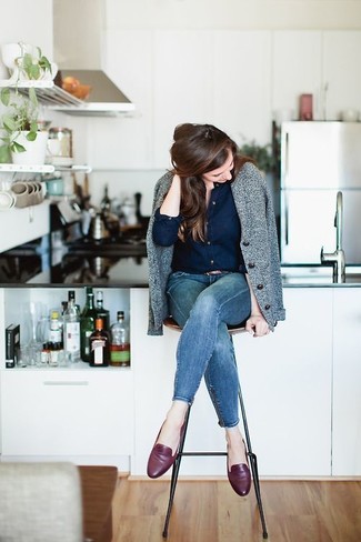 С чем носить темно-синие джинсы скинни осень в стиле смарт-кэжуал: Серая шерстяная косуха в сочетании с темно-синими джинсами скинни — отличная идея для воплощения лука в элегантно-деловом стиле. Весьма выигрышно здесь смотрятся темно-красные кожаные лоферы. Такое сочетание базовых вещей гарантирует, что твой осенний наряд не будет скучным.