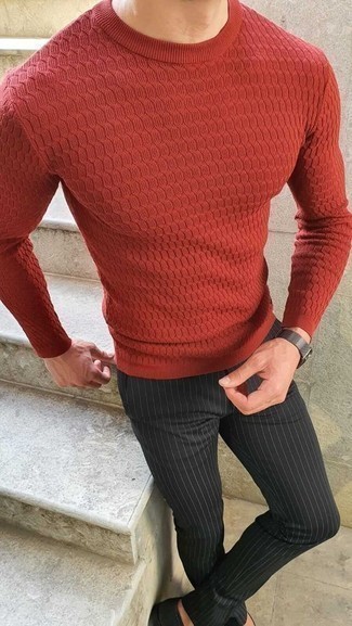 С чем носить красный свитер в 30 лет мужчине: Образ из красного свитера и черных брюк чинос в вертикальную полоску — хороший пример современного городского стиля.