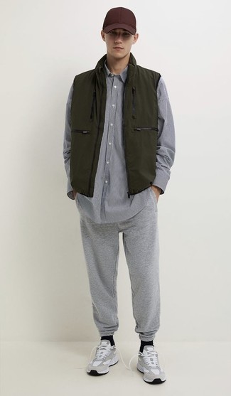 Мода для 20-летних мужчин: Оливковая куртка без рукавов и серые спортивные штаны — неотъемлемые составляющие в гардеробе парней с отменным вкусом в одежде.