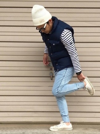 Как носить белые низкие кеды с голубыми джинсами в 30 лет мужчине: Если ты ценишь комфорт и практичность, не обходи стороной это сочетание темно-синей стеганой куртки без рукавов и голубых джинсов. Весьма органично здесь смотрятся белые низкие кеды.
