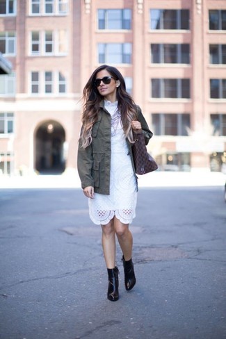 Модный лук: оливковая куртка в стиле милитари, белое кружевное платье-футляр, черные кожаные ботильоны, темно-коричневая кожаная большая сумка с принтом